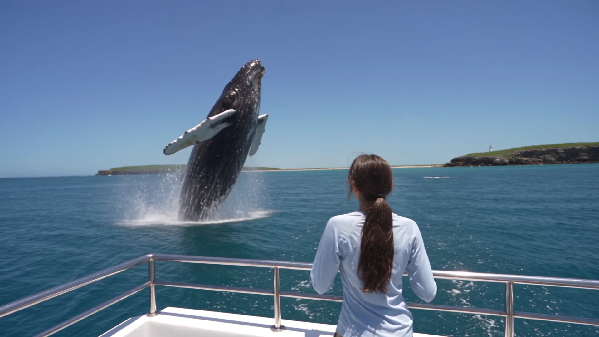 Menina na proa de um catamarã vendo uma baleia jubarte saltar em Abrolhos, plano gerado por IA